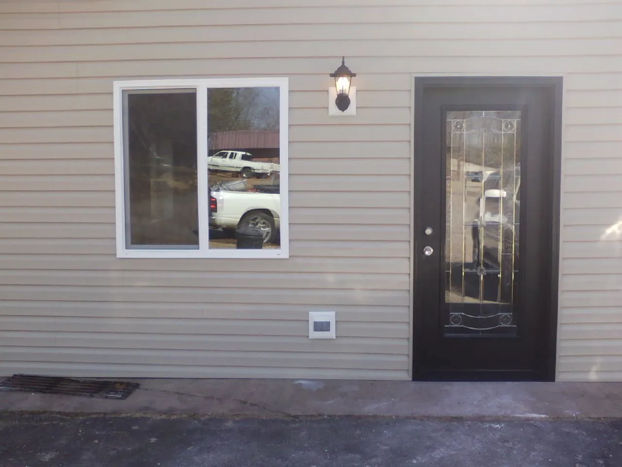 New siding, window and entry door on the side of an addition in Holladay