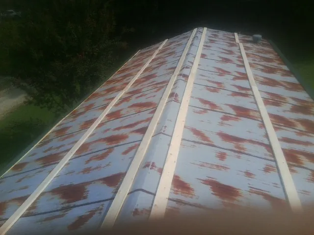 Rusted metal roof panels with new wood purlins before replacement — Storm Damage Roof Repair in Holladay by Roofing Brothers