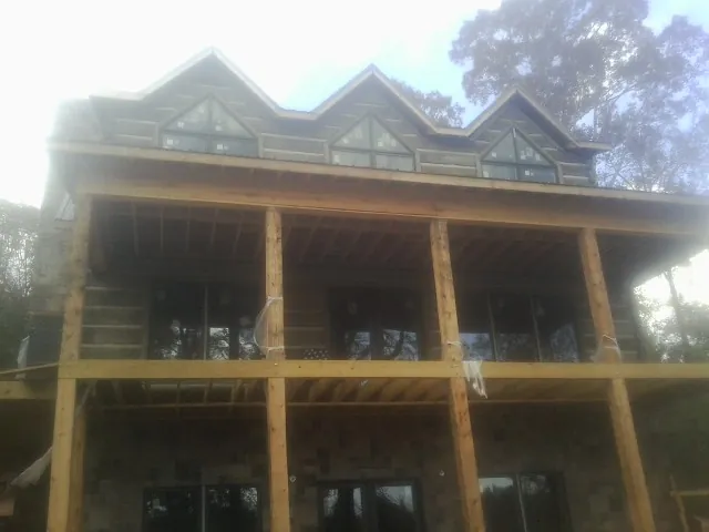 Dormers and porch framing on a large log home under construction — Roof Coating work by our crew in Holladay