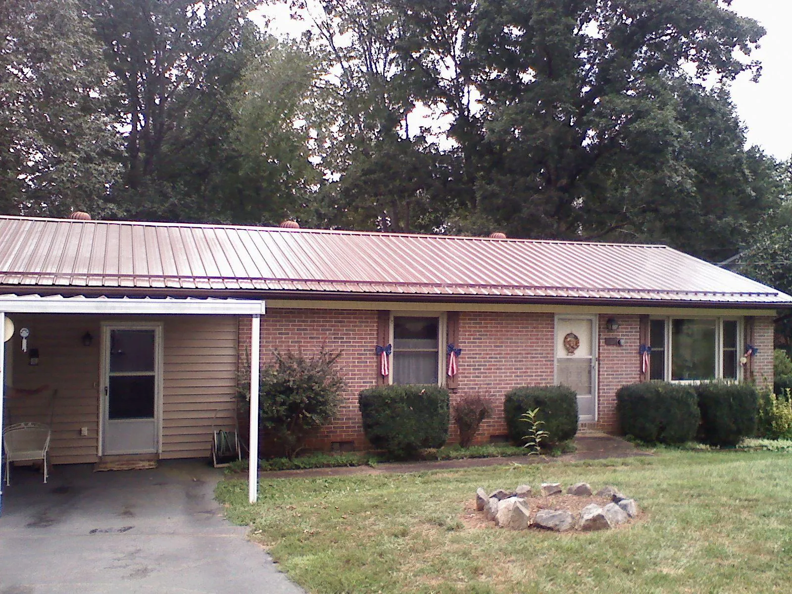 Bronze metal roof and carport on a brick ranch home — Roof Repair work by our crew in Holladay